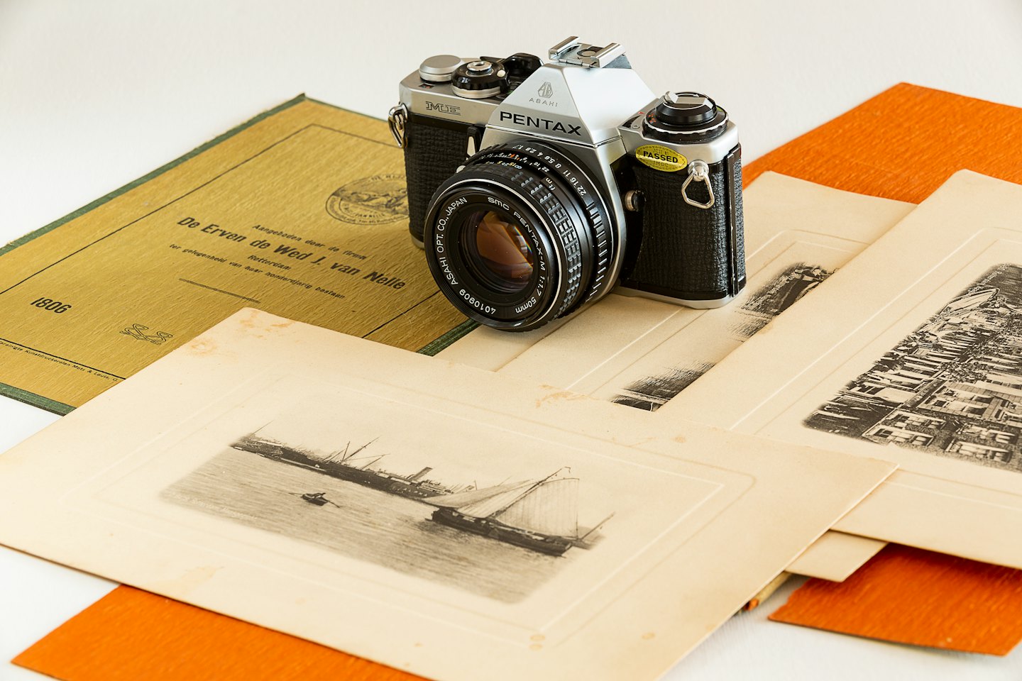 Vintage filmcamera rustend op een stapel historische documenten.