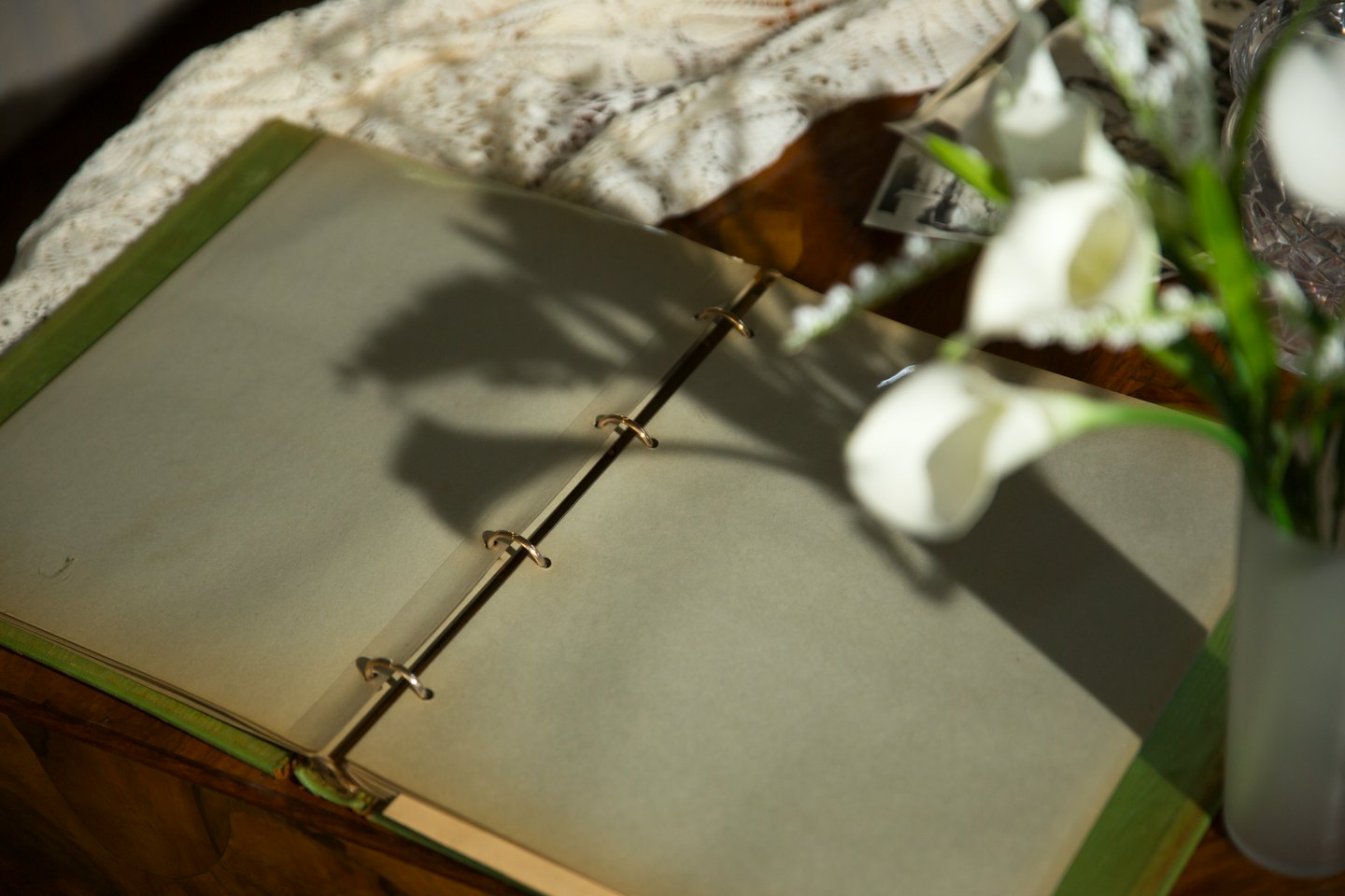 Open groen fotoalbum op een houten tafel.