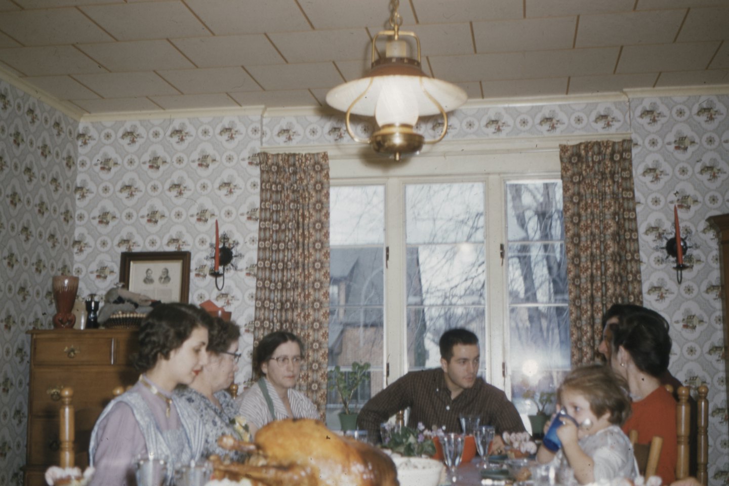 Meerdere generaties van een familie genieten van een feestmaal aan een eettafel.